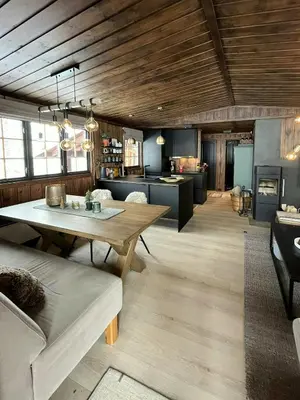 a living room with a table and a kitchen at Modern Mountain Cabin With Views Over Slokovannet in Nore