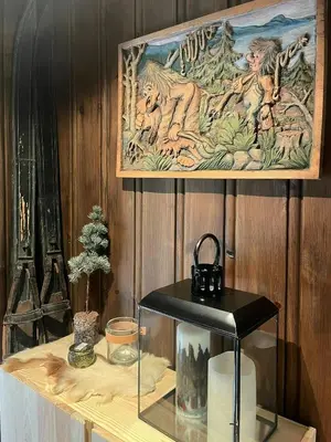 a painting hanging on a wooden wall above a shelf at Modern Mountain Cabin With Views Over Slokovannet in Nore