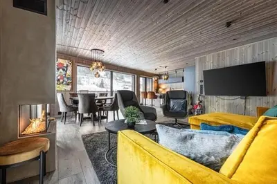 a living room with a yellow couch and a dining room at Ski out ski in Luxus Hemsedal in Hemsedal
