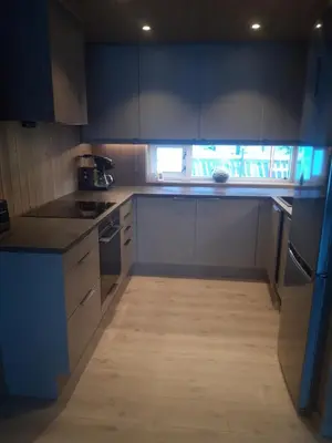 a kitchen with blue cabinets and a wooden floor at Kvamsfjellet - Rondane in Nord-Fron