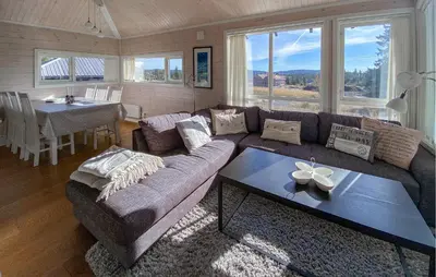 a living room with a couch and a table at 3 Bedroom Cozy Home In Sjusjøen in Sjusjøen