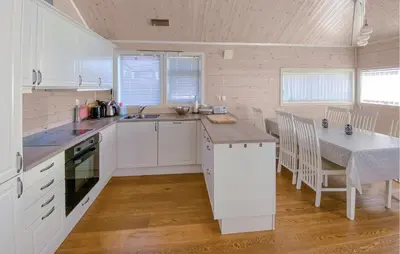 a kitchen with white cabinets and a table and a counter at 3 Bedroom Cozy Home In Sjusjøen in Sjusjøen