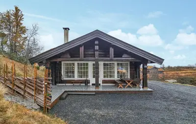 a wooden cabin with a porch and a fence at Cozy Home In Rauland With Wifi in Rauland