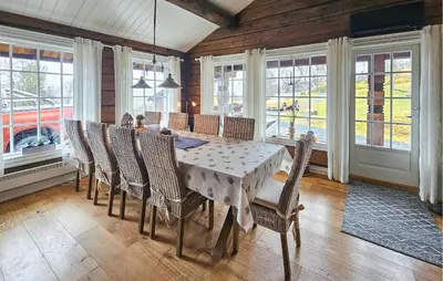 a dining room with a table and chairs and windows at Cozy Home In Rauland With Wifi in Rauland