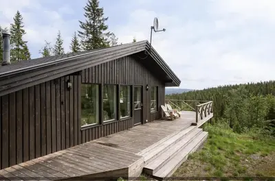 a cabin with a wooden porch and a deck at Trysilfjellet Nord 267 in Trysil
