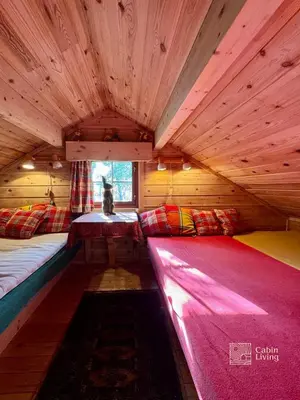 a room with two beds in a wooden cabin at Ski in-out cabin Trysil sauna, fireplace and views in Trysil