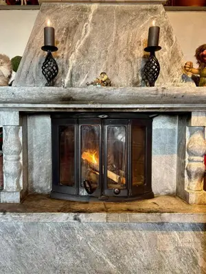 a stone fireplace with a fire in it at Ski in-out cabin Trysil sauna, fireplace and views in Trysil