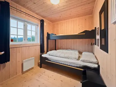 a bedroom with a bunk bed in a wooden room at Mountain cabin in Aurdal Fireplace Sauna 1000 meters above sea level in Aurdal
