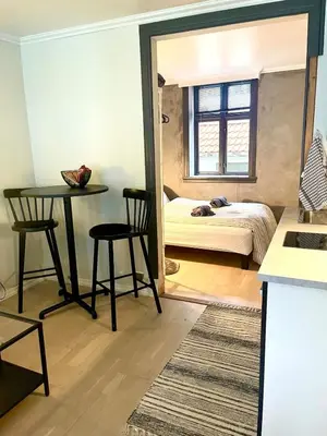 a room with a bed and a table and chairs at Central studio apartment in Bergen