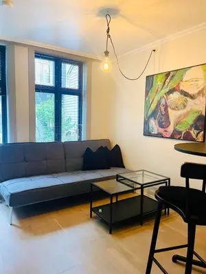 a living room with a couch and a table at Central studio apartment in Bergen