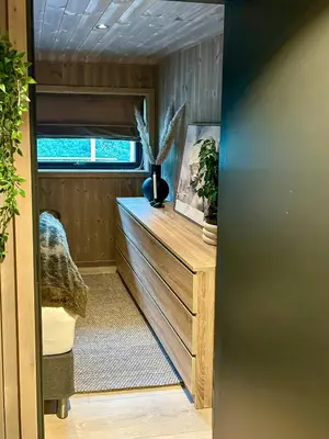 a room with a wooden dresser and a window at Renovated Cabin With Views Over Breimsvatnet in Klakegg