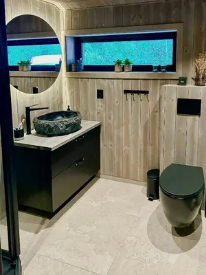 a bathroom with a toilet and a sink and a window at Renovated Cabin With Views Over Breimsvatnet in Klakegg