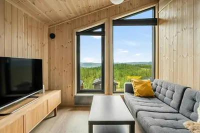 a living room with a couch and a large window at Mountain Cabin With Panoramic Views In Norefjell in Noresund