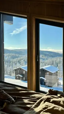 a bedroom with a view of a house from a window at Mountain Cabin With Panoramic Views In Norefjell in Noresund