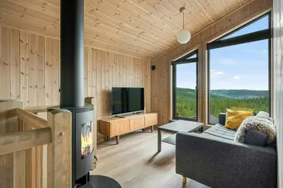 a living room with a fireplace and a television at Mountain Cabin With Panoramic Views In Norefjell in Noresund