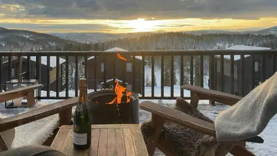 a bottle of wine sitting on a table with a fire at Mountain Cabin With Panoramic Views In Norefjell in Noresund