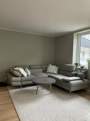 a living room with a couch and a table at Private room close to the Bybane at Fantoft in Bergen