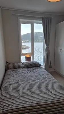 a bedroom with a large bed with a large window at Apartment in Ålesund in Ålesund