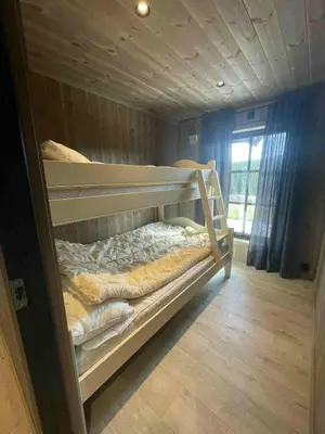 a bunk bed in a room with a window at New cabin in Slåseterlia at Skeikampen in Svingvoll
