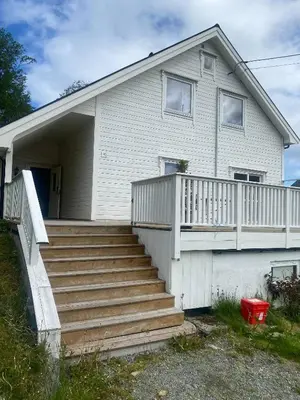 a house with a staircase in front of it at Mountain Retreat in Brattvg - Unwind in Nature in Brattvåg