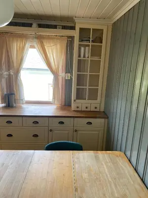 a kitchen with a wooden table and a window at Mountain Retreat in Brattvg - Unwind in Nature in Brattvåg