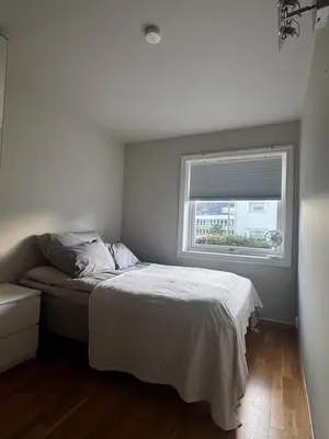 a small bedroom with a bed and a window at Gimleveien 36G in Bergen