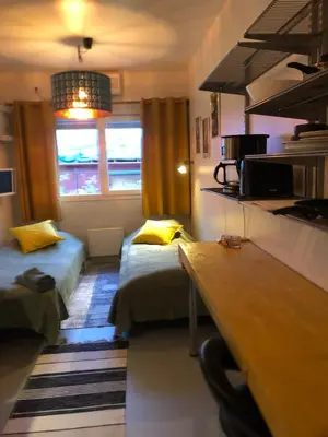 a small room with two beds and a desk at Compact living with all you need, close to the centre! in Røros