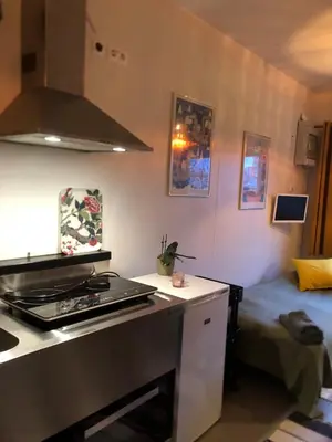 a kitchen with a stove and a bed in a room at Compact living with all you need, close to the centre! in Røros