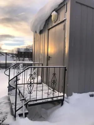 a balcony with snow on it next to a building at Compact living with all you need, close to the centre! in Røros