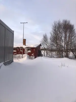 a building covered in snow next to a building at Compact living with all you need, close to the centre! in Røros