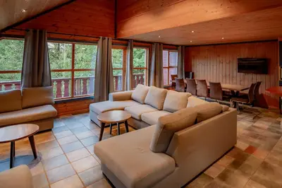 a living room with couches and a table and chairs at Bakkebyvegen 7A in Trysil