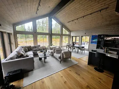 a living room with a couch and chairs and a table at Unique hytta with jacuzzi, sauna, 7 bedrooms in Trysil