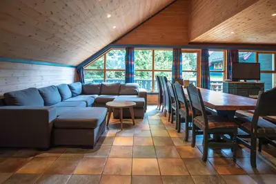 a living room with a couch and a table and chairs at Bakkebyvegen 13A in Trysil