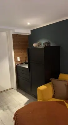 a living room with a yellow couch and a kitchen at Charming apartment with lodgefeeling in Hemsedal