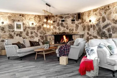 a living room with couches and a stone wall at Charming apartment with lodgefeeling in Hemsedal