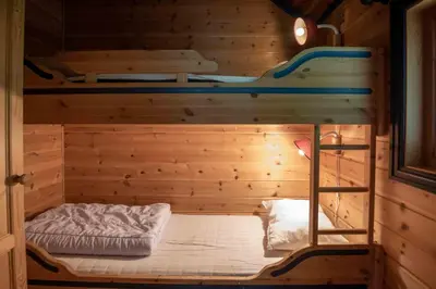 a room with a bunk bed in a wooden cabin at Bakkebyvegen 13B in Trysil