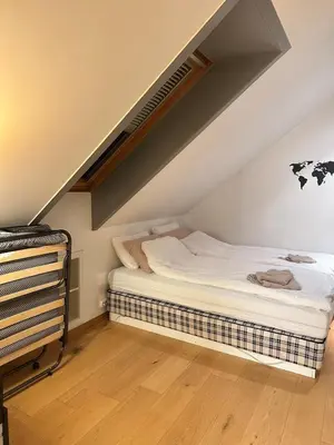 a bedroom with a bed in a attic at Bright loft apartment in a Jugend-style building close to Brosund in Ålesund