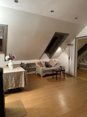 a living room with a couch and a table at Bright loft apartment in a Jugend-style building close to Brosund in Ålesund