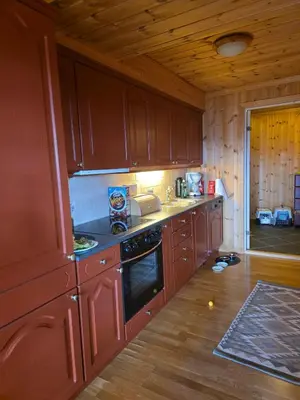 a kitchen with wooden cabinets and a stove top oven at Fjellstolen apartment nr 12 in Beitostøl