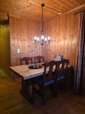 a dining room table with chairs and a chandelier at Fjellstolen apartment nr 12 in Beitostøl