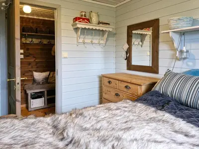 a bedroom with a bed and a mirror and a dresser at Cozy Family Cabin At Hamlagrø in Vossevangen