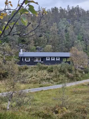a black house on a hill in a field at Cozy Family Cabin At Hamlagrø in Vossevangen