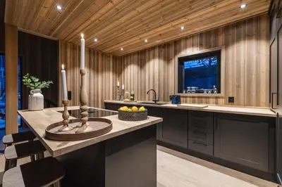 a kitchen with wooden walls and a counter with a sink at Nyørk Chalet, Hemsedal in Hemsedal