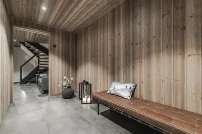 a room with a wooden wall with a bench and a staircase at Nyørk Chalet, Hemsedal in Hemsedal