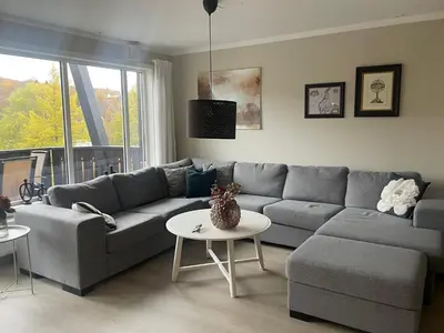 a living room with a couch and a table at Hjemmekoselig Toppleilighet I Sentrum in Beitostøl