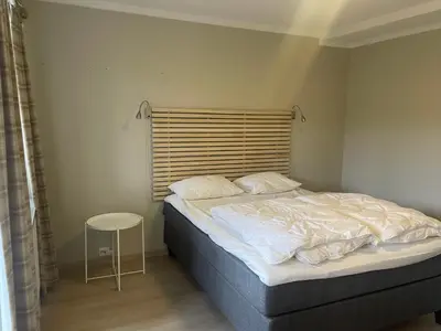 a bedroom with a bed with a wooden headboard at Hjemmekoselig Toppleilighet I Sentrum in Beitostøl