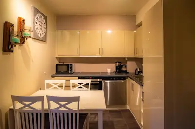a kitchen with white cabinets and a table and chairs at Høyfjellsgrend 961, 36b in Trysil