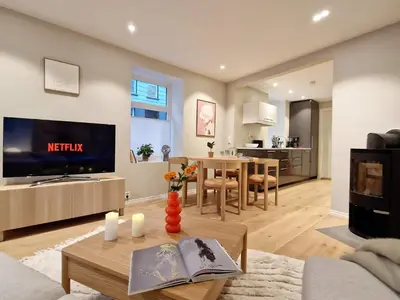 a living room with a television and a dining room at King Bed Renovated and Cozy Near Bryggen in Bergen