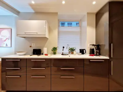 a kitchen with brown cabinets and a white counter top at King Bed Renovated and Cozy Near Bryggen in Bergen