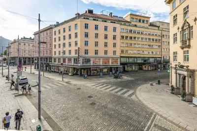 an empty street in a city with many buildings at Torgalmenningen Town Square, Yet quiet, Elevator in building in Bergen